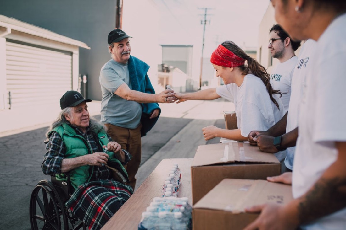 Volunteers handing out food and water to people in need